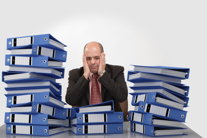 Overloaded man at desk
